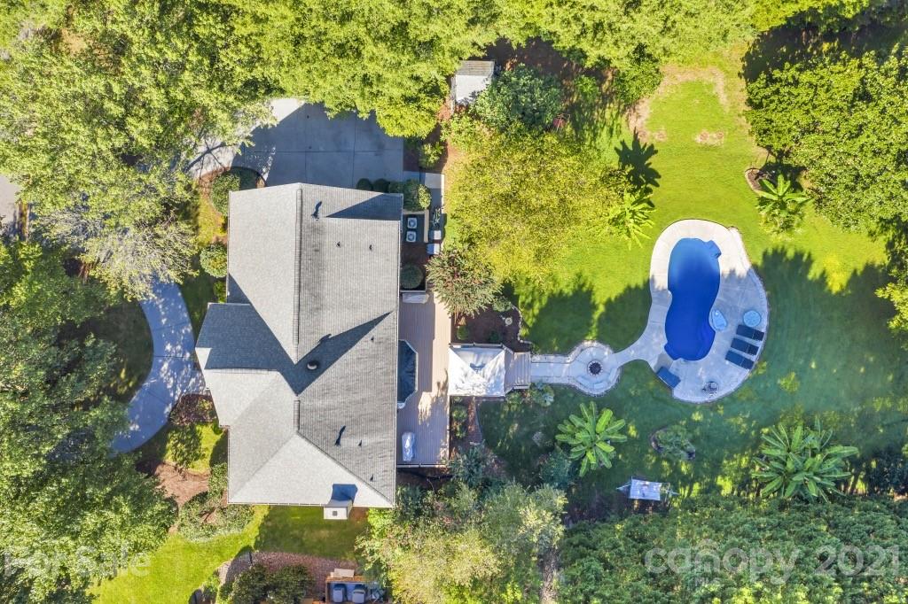 an aerial view of a house with swimming pool and garden space