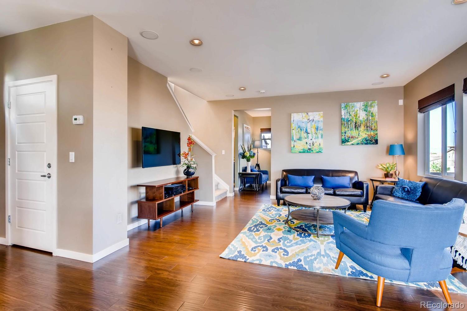 a living room with furniture flat screen tv and wooden floor