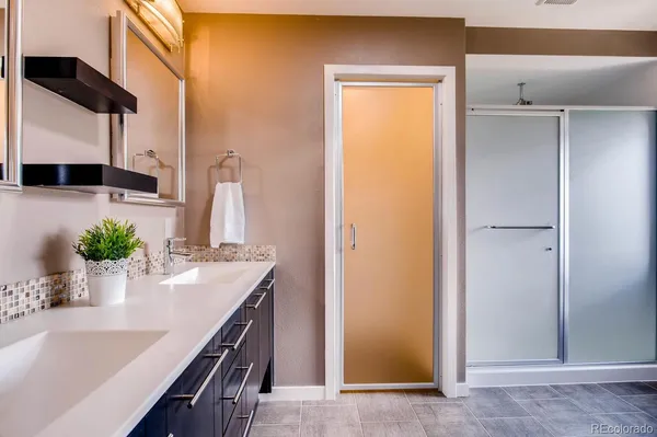 a kitchen with stainless steel appliances a sink a potted plant and cabinets