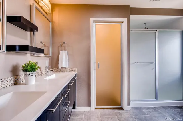 a kitchen with stainless steel appliances a sink a potted plant and cabinets
