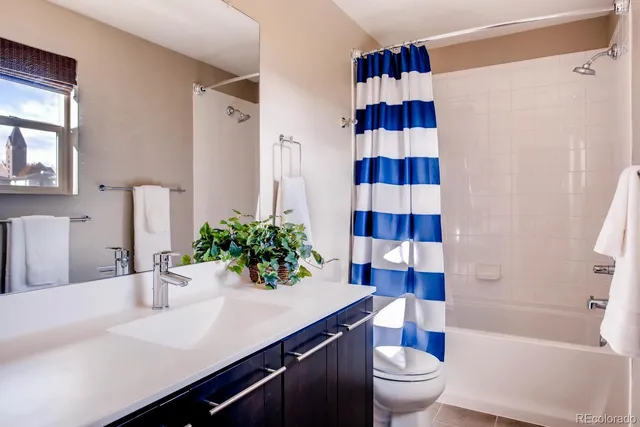 a bathroom with a sink a toilet and shower curtain
