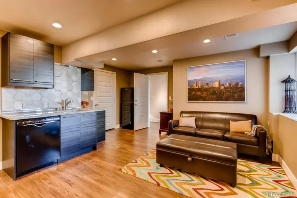 a large living room with stainless steel appliances kitchen island granite countertop a refrigerator stove top oven and sink