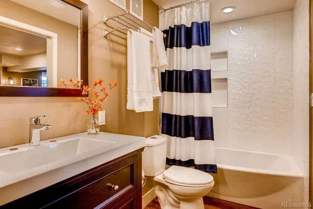 a bathroom with a sink a toilet and shower curtain