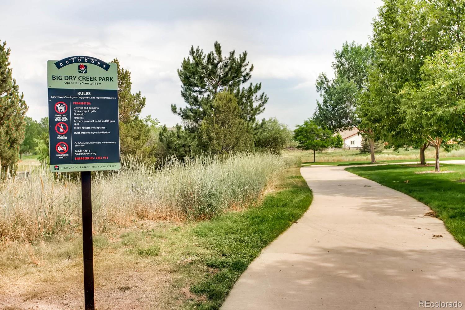 3435 Cranston Circle Highlands Ranch, CO 80126 - Photo 39 of 40 a view of a lake with a bench under large trees