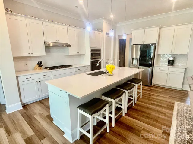 a kitchen with a stove a refrigerator and a stove top oven