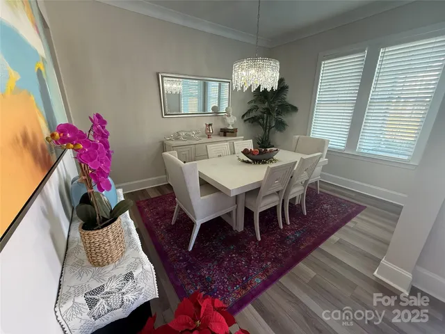 a bedroom with a bed a mirror on dresser and a chandelier