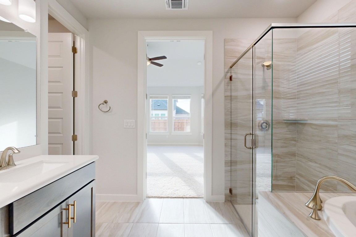 2029 Billings Way Leander, TX 78641 - Photo 17 of 29 a bathroom with a granite countertop sink a mirror and shower