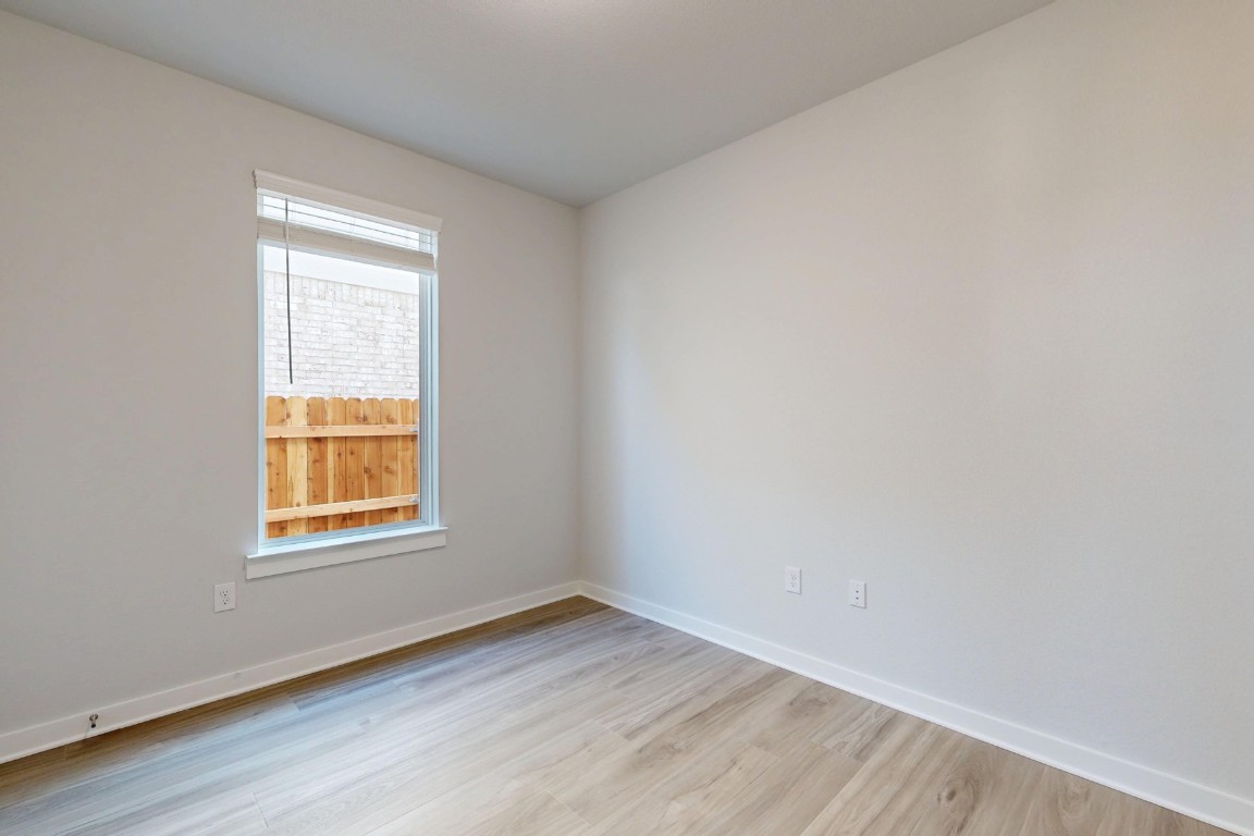 2029 Billings Way Leander, TX 78641 - Photo 9 of 29 a view of an empty room with wooden floor and a window