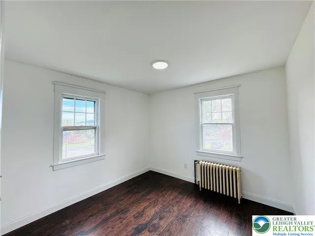 a view of a room with wooden floor and windows