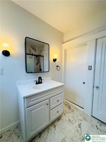 a bathroom with a sink a mirror and vanity