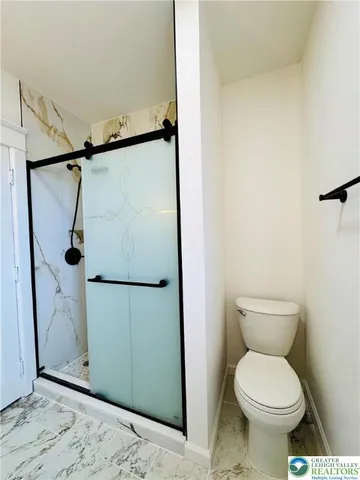 a bathroom with a toilet and a shower