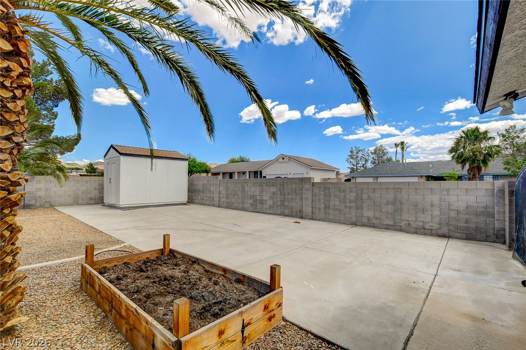 1810 Pinto Road Henderson, NV 89002 - Photo 49 of 53 A spacious, paved backyard with a practical storage shed and a raised garden bed awaits.