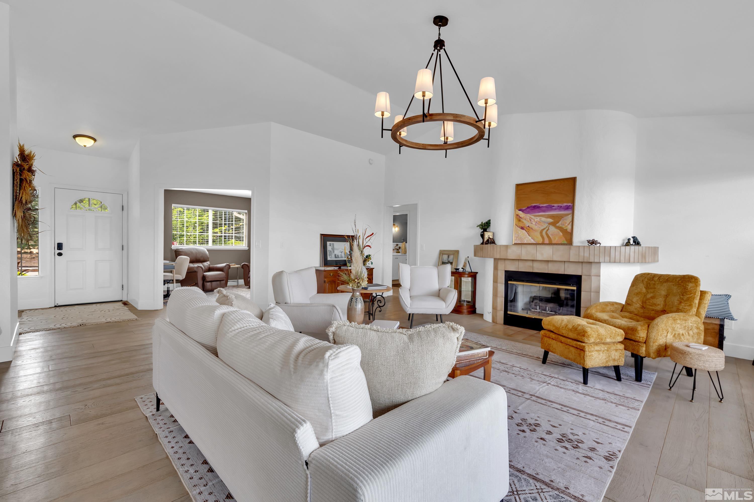 962 University Ridge Court Reno, NV 89512 - Photo 3 of 40 a living room with furniture a fireplace and a chandelier