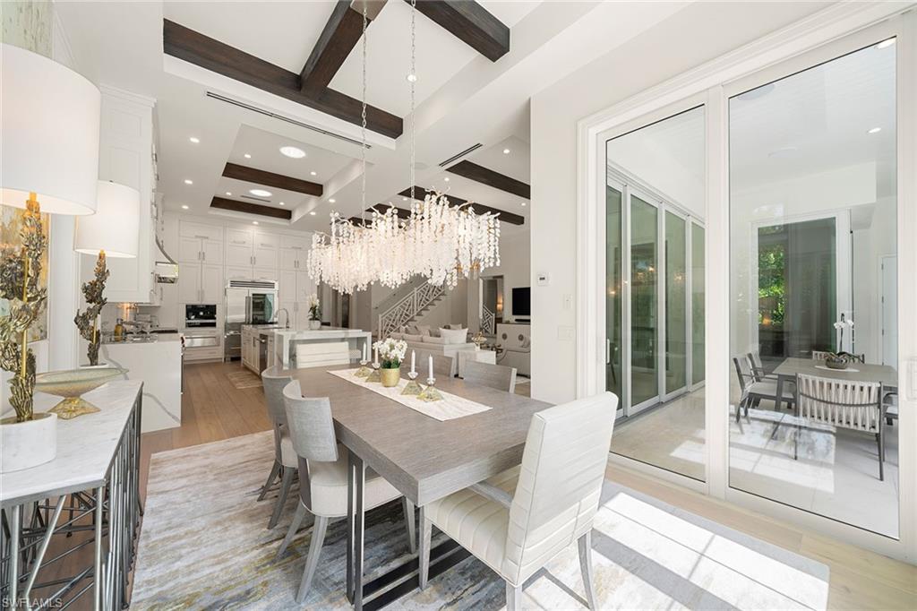 150 6th Street North Naples, FL 34102 - Photo 11 of 46 a dining room with furniture a chandelier and wooden floor
