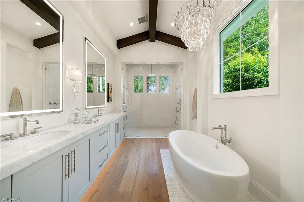 150 6th Street North Naples, FL 34102 - Photo 17 of 46 a bathroom with a double vanity sink and a bathtub
