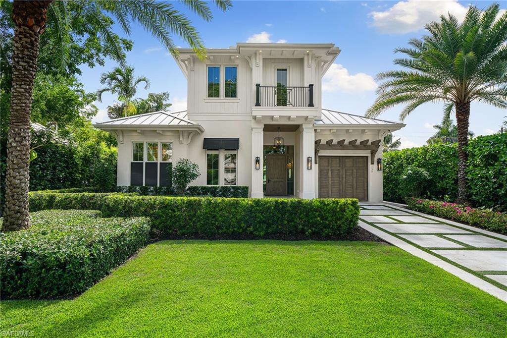 150 6th Street North Naples, FL 34102 - Photo 2 of 46 a front view of a house with a garden