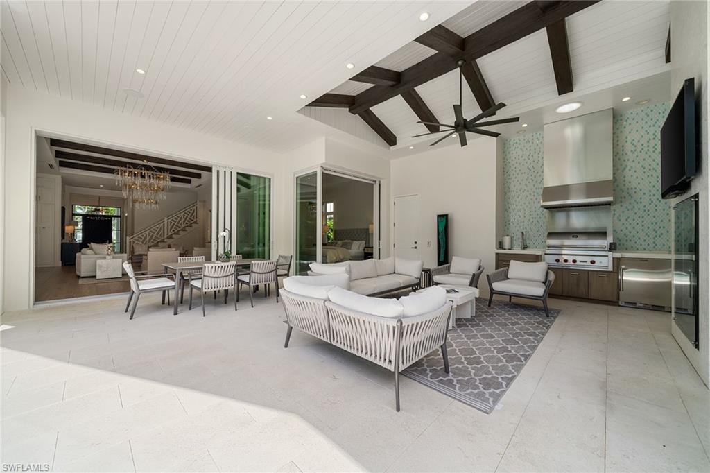 150 6th Street North Naples, FL 34102 - Photo 22 of 46 a living room with furniture a flat screen tv and a table