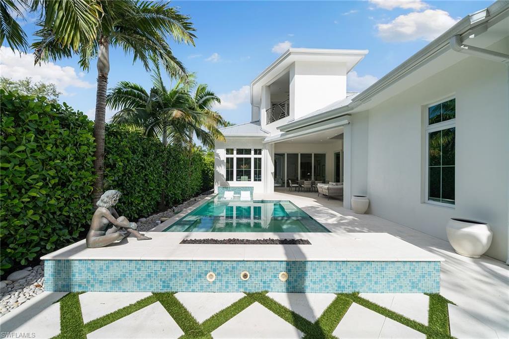150 6th Street North Naples, FL 34102 - Photo 26 of 46 a front view of house with yard trampoline and green space