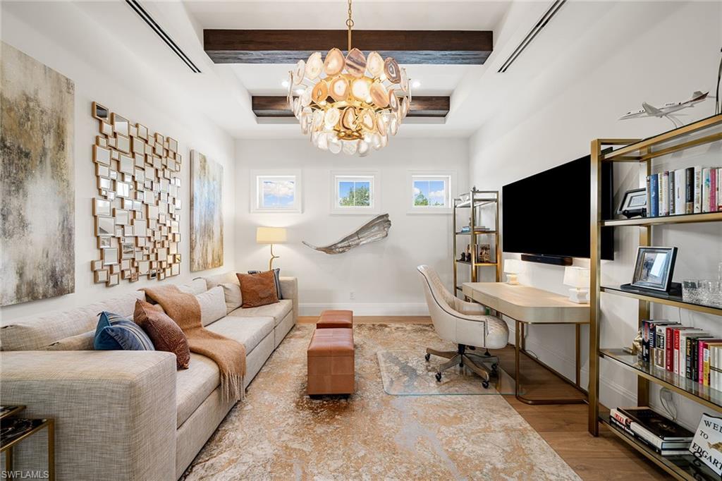 150 6th Street North Naples, FL 34102 - Photo 31 of 46 a living room with furniture a flat screen tv and a floor to ceiling window