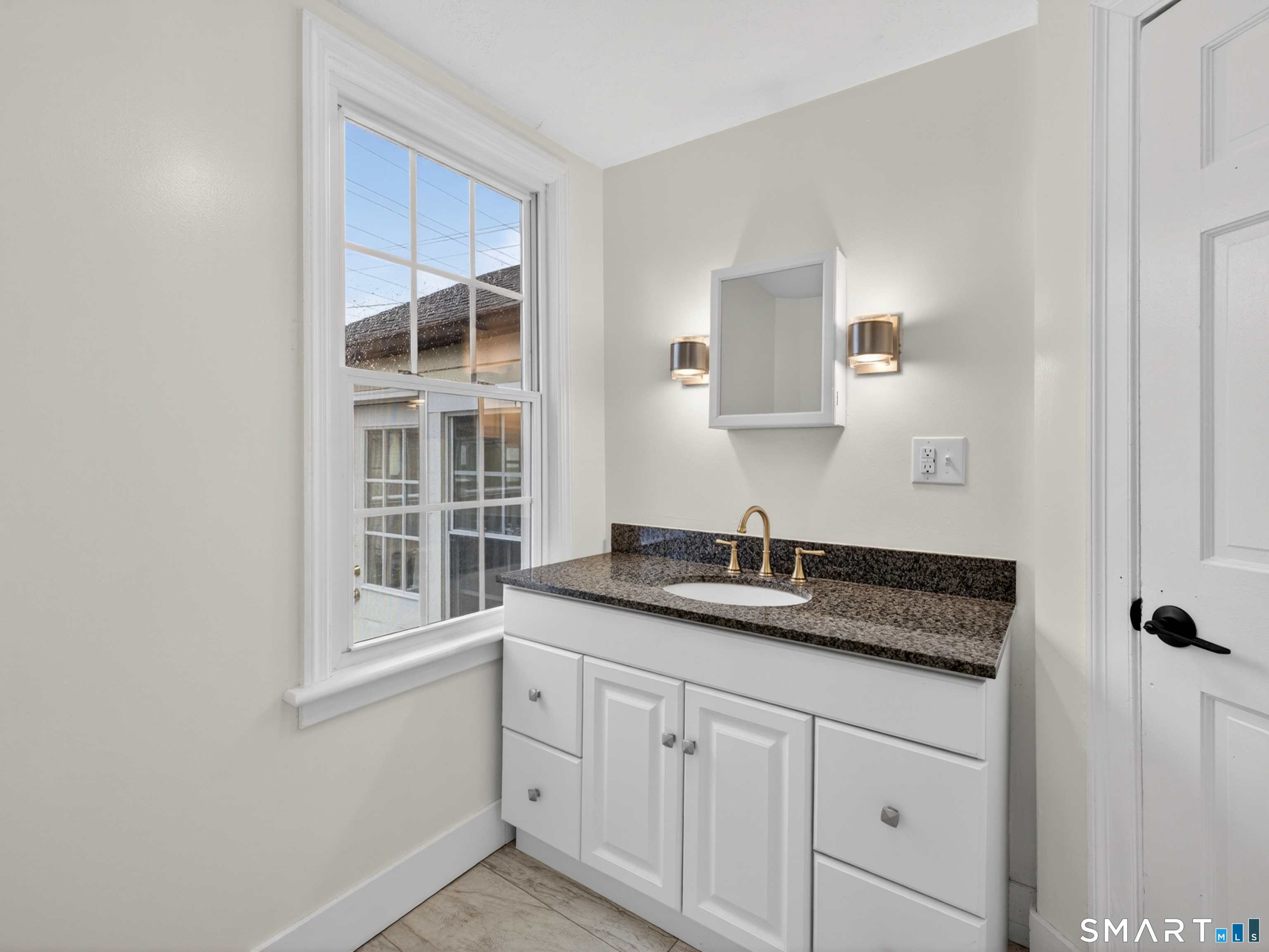 380 Main Street Meriden, CT 06451 - Photo 17 of 40 a bathroom with a granite countertop sink and mirror with window