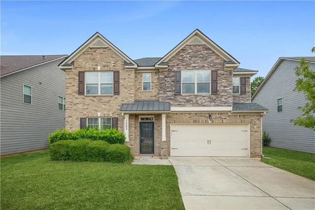 a front view of a house with a yard and garage