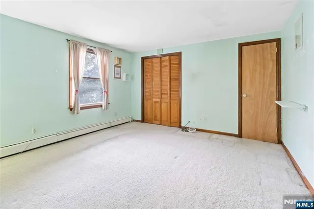 an empty room with windows and closet