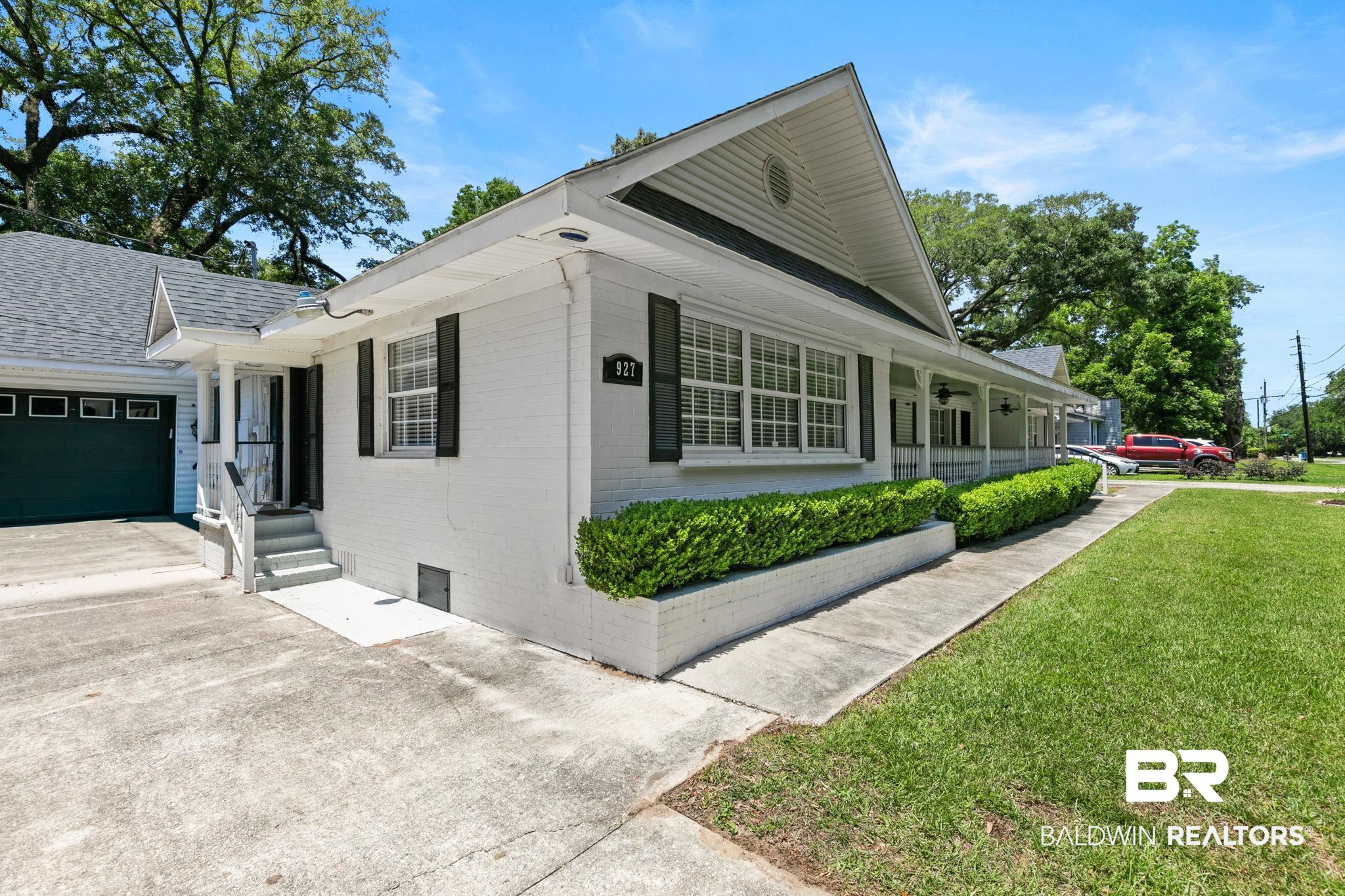 927 Cleveland Road Saraland, AL 36571 - Photo 71 of 80 White brick exterior with black window shutters and a covered front porch