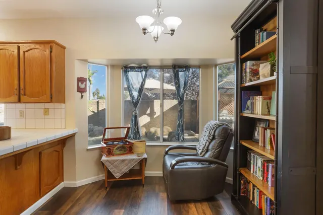 a living room with furniture a bookshelf and a window