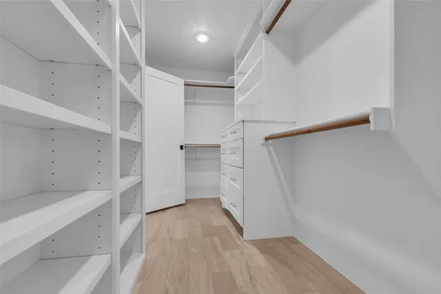 a view of walk in closet with empty racks