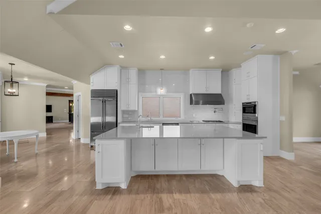 a large kitchen with stainless steel appliances lots of counter top space and cabinets