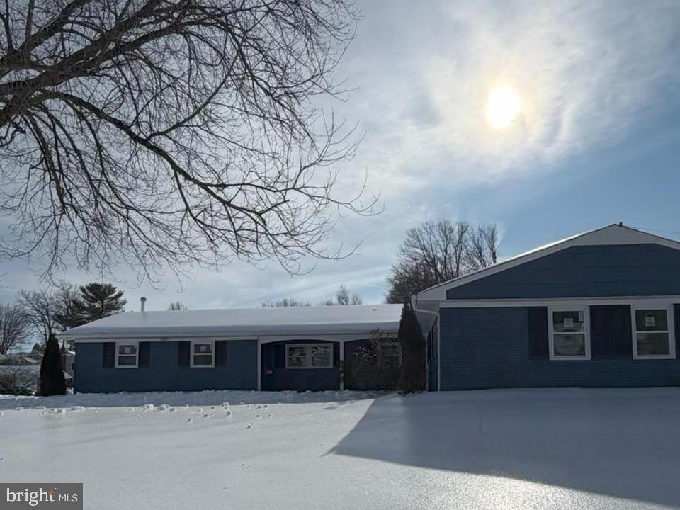 a front view of house with yard and trees in the background