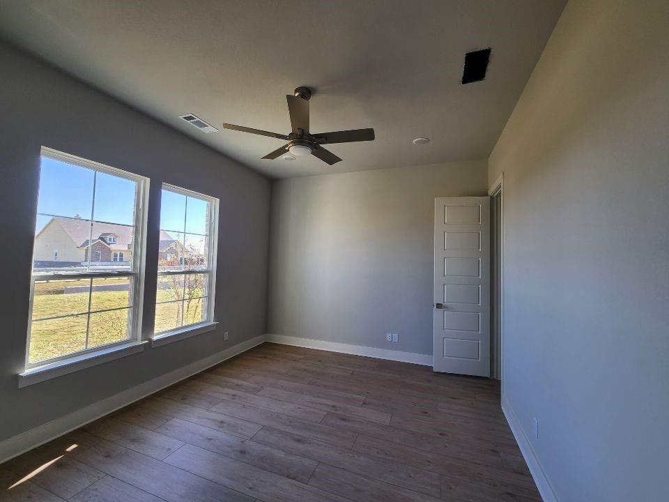 2321 Quartz Street Krum, TX 76249 - Photo 4 of 19 a view of an empty room with a window and wooden floor