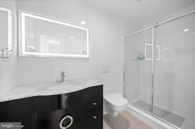 a bathroom with a sink vanity toilet and shower