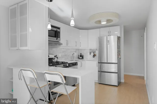 a kitchen with stainless steel appliances a refrigerator stove microwave and white cabinets