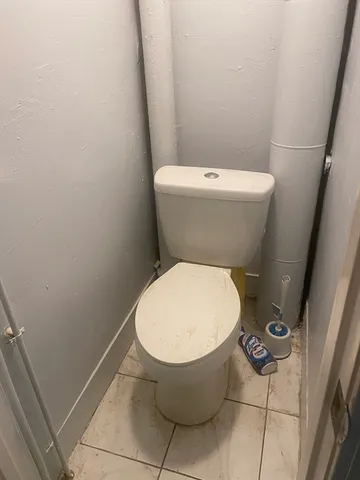 a white toilet sitting next to a white sink and vanity
