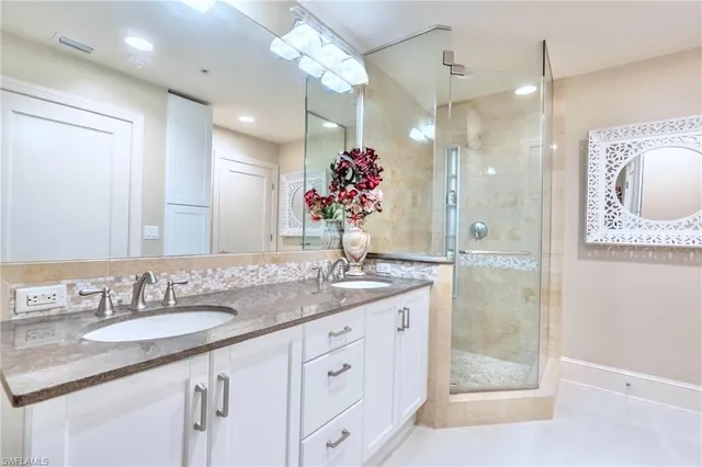 a bathroom with a granite countertop sink a shower and a mirror
