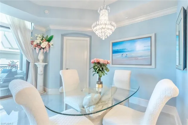 a view of a dining room with furniture a chandelier and wooden floor