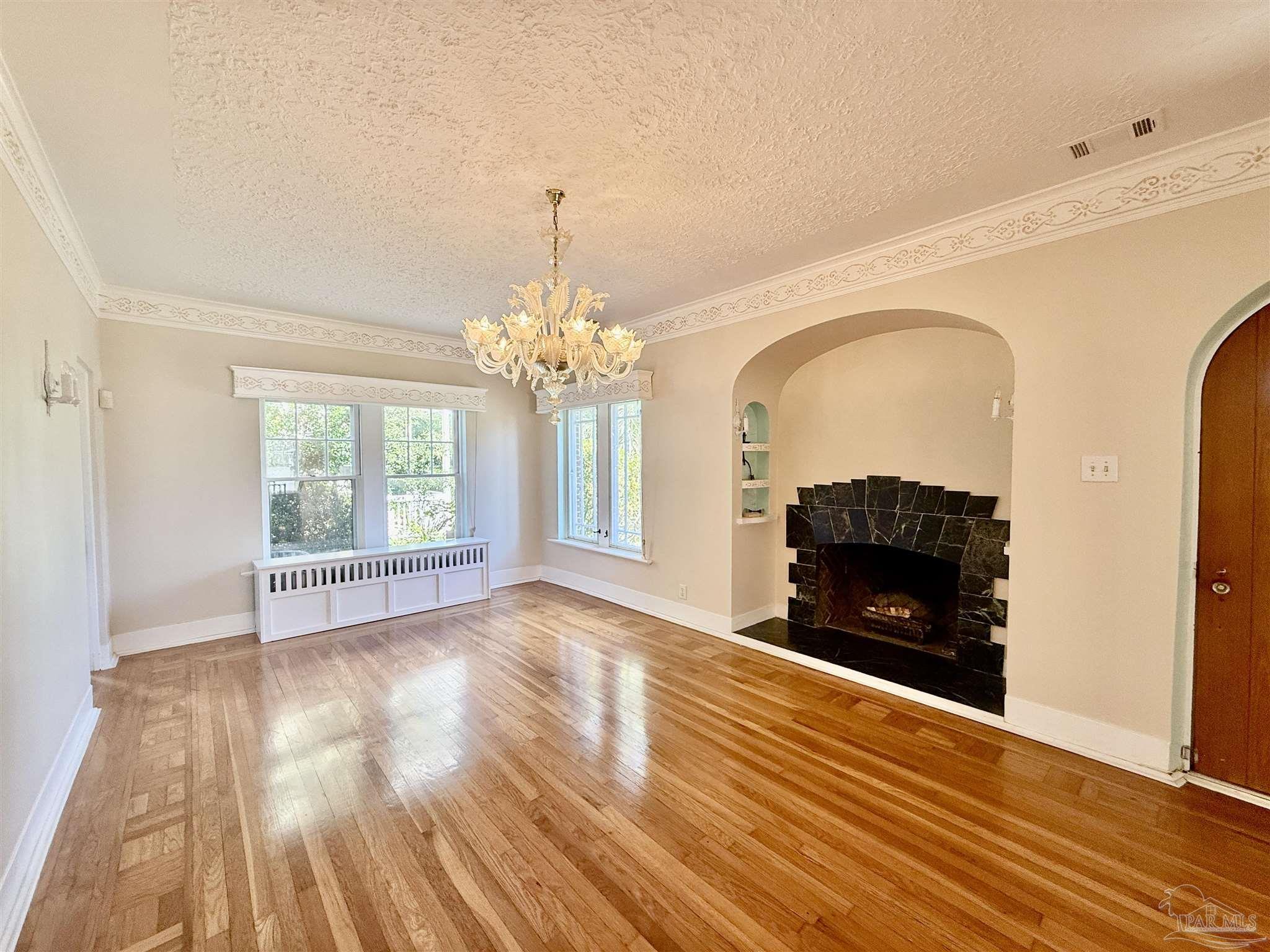 a view of livingroom with fireplace chandelier and wooden floor