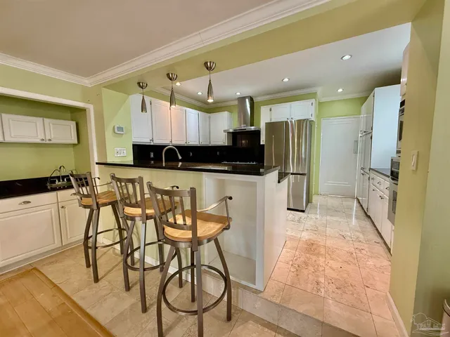 a kitchen with stainless steel appliances kitchen island granite countertop a refrigerator and a stove top oven