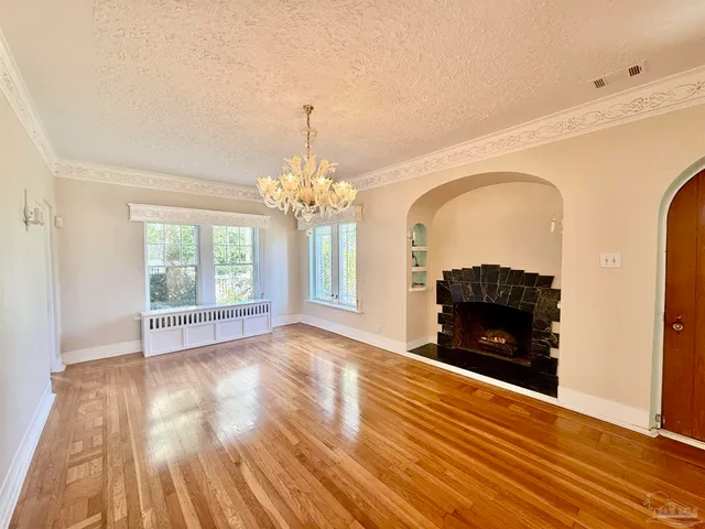 a view of livingroom with fireplace chandelier and wooden floor
