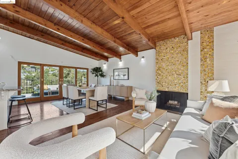 a living room with fireplace furniture and a large window
