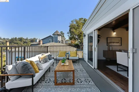 a kitchen with stainless steel appliances granite countertop a stove top oven a sink dishwasher a dining table and chairs with wooden floor