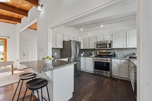 a kitchen with stainless steel appliances granite countertop a stove a sink and a microwave