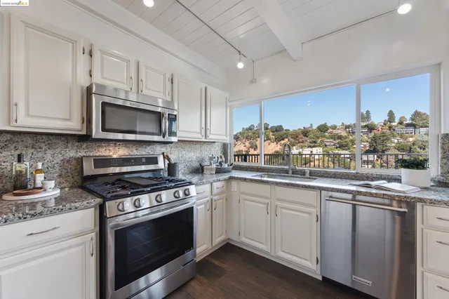 a kitchen with stainless steel appliances a refrigerator and wooden floor