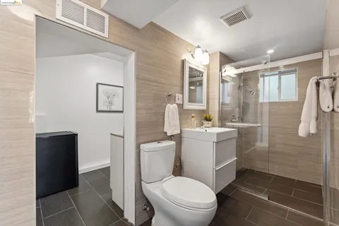 a bathroom with a bathtub shower sink mirror and toilet