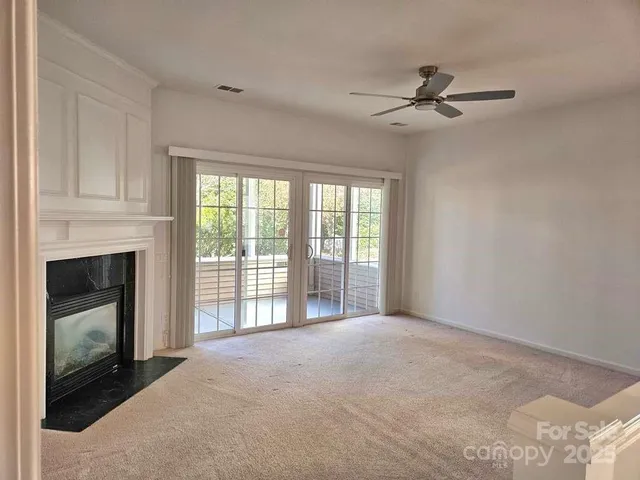 a view of an empty room with a fireplace and a window