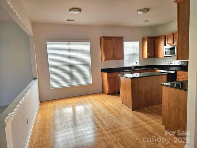 a kitchen with stainless steel appliances granite countertop a stove a sink and a refrigerator