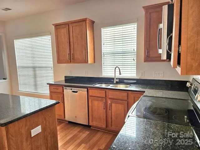 a kitchen with stainless steel appliances granite countertop a sink stove and granite counter top
