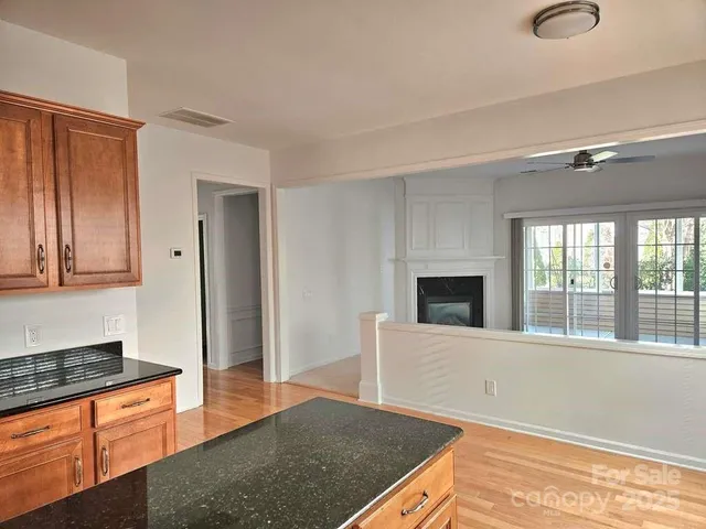 a living room with stainless steel appliances granite countertop a stove and a sink