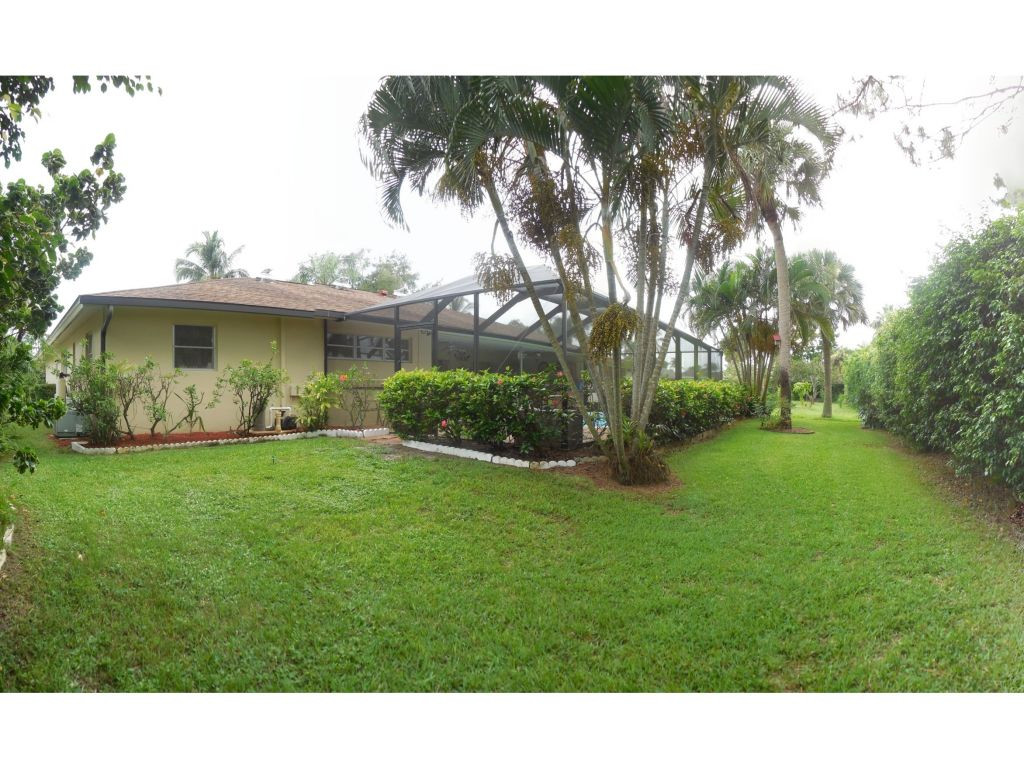 4517 Parrot Avenue Naples, FL 34104 - Photo 3 of 13 a view of a backyard with plants and palm trees